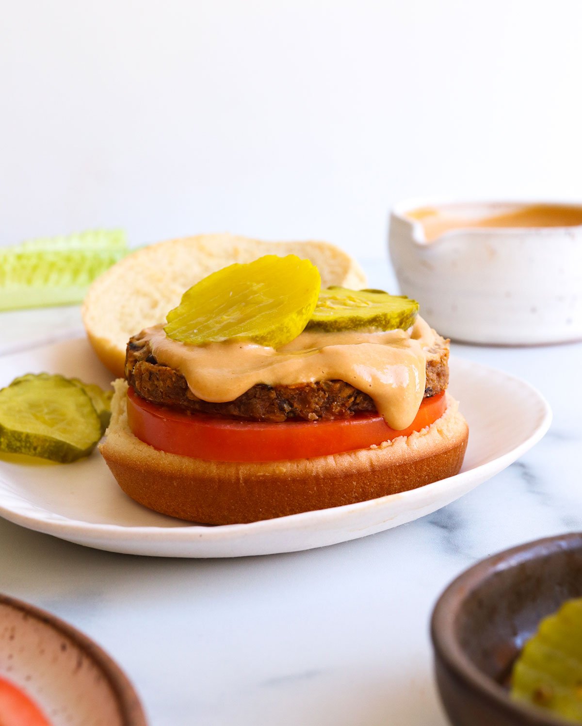 vegan burger sauce dripping off of a patty stacked on a bun.