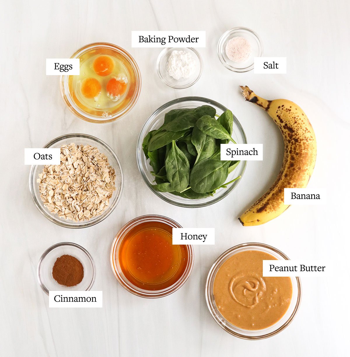 spinach muffin ingredients labeled in glass bowls.