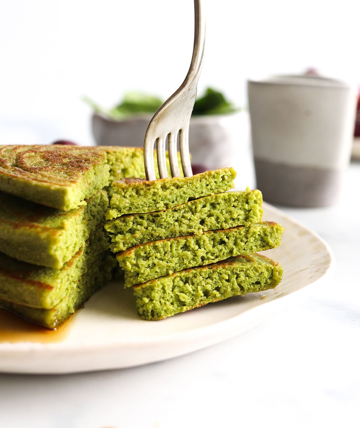 Spinach pancakes sliced with a bite on fork.