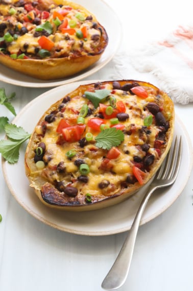 southwest stuffed spaghetti squash served with a fork on a white plate.