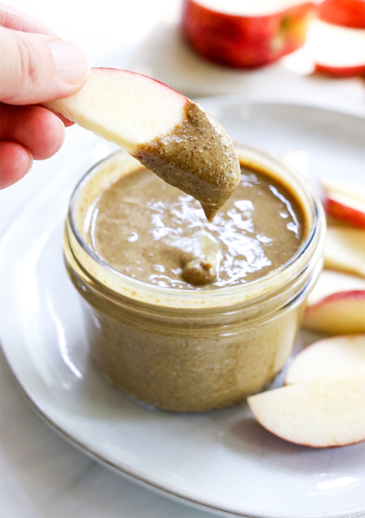 apple slice dipped into sunflower seed butter.