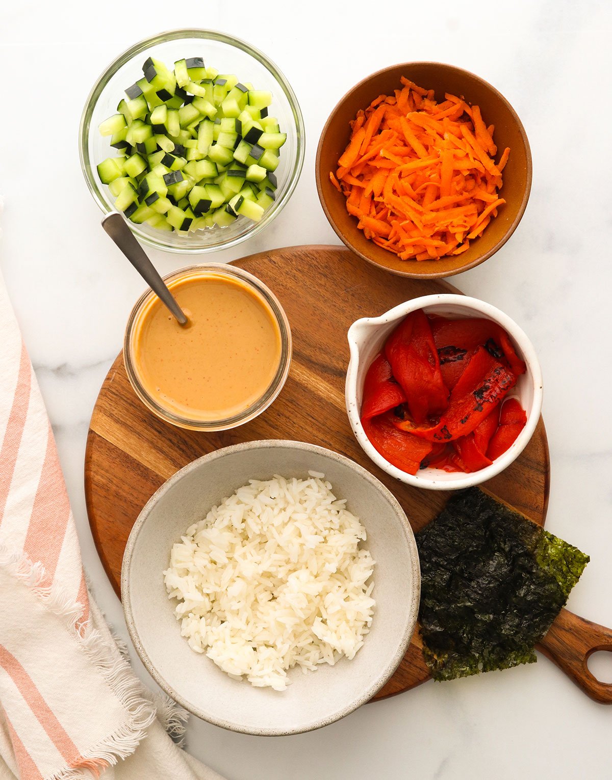 cooked rice veggies and sauce arranged on a cutting board.