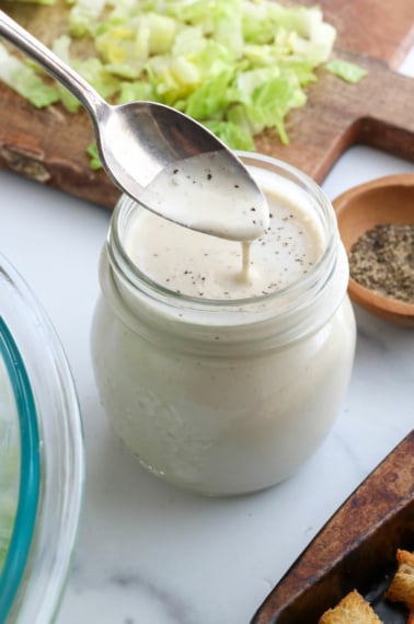 vegan caesar dressing dripping off a spoon