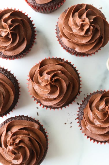 vegan ganache piped over chocolate cupcakes from overhead angle.