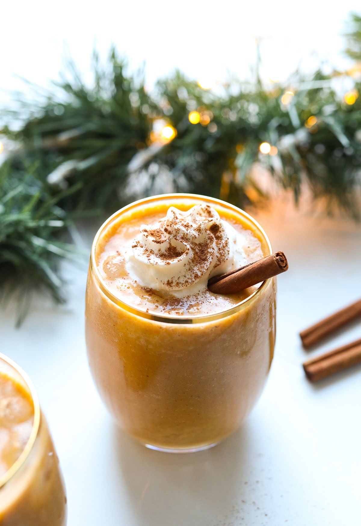 Vegan eggnog topped with whipped cream and cinnamon.