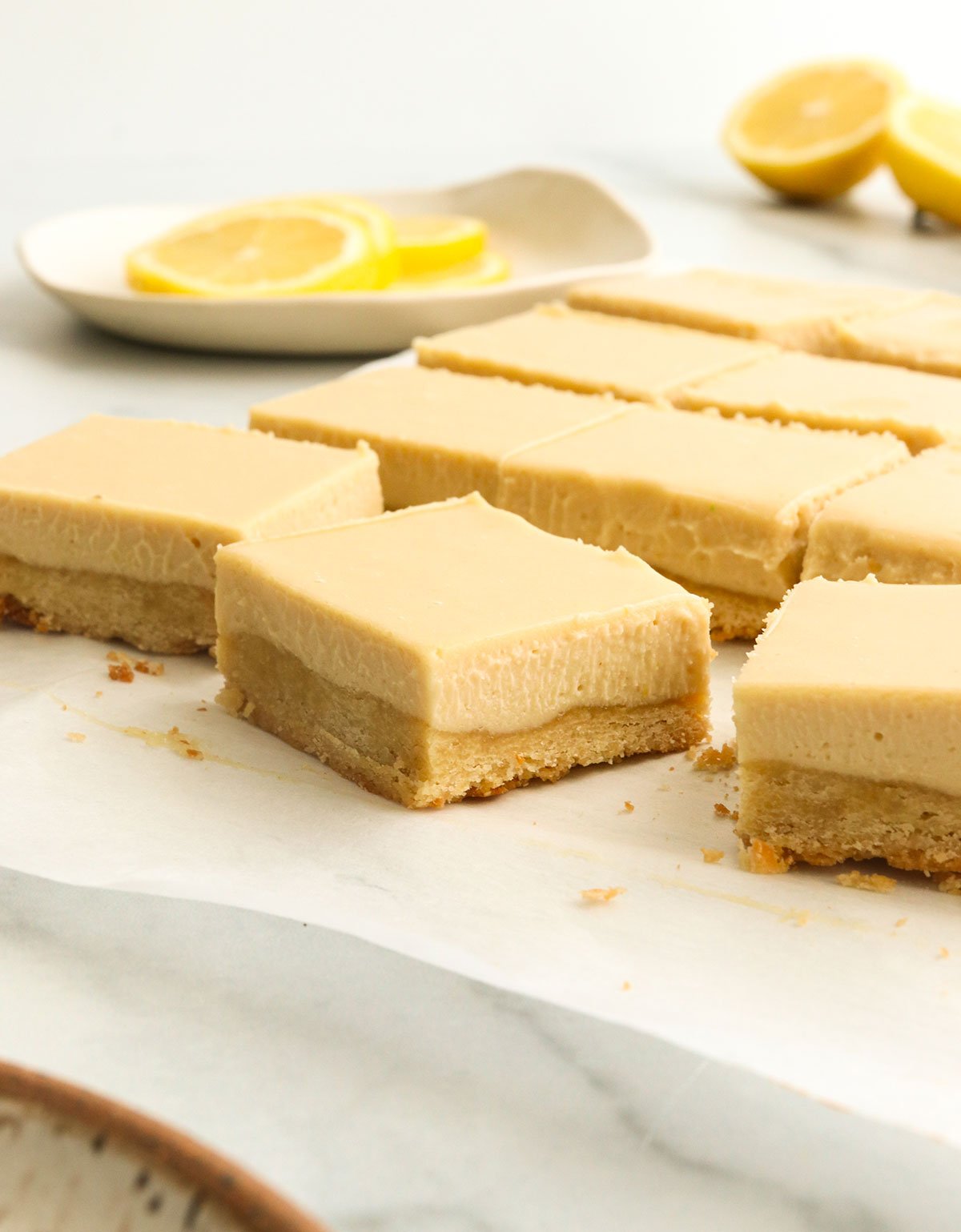 lemon bars sliced into squares on parchment paper.