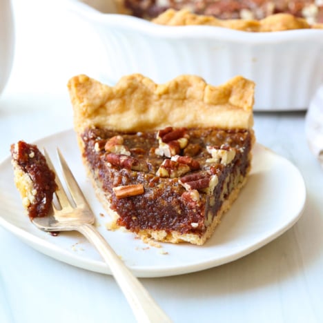 vegan pecan pie slice with bite removed on a fork.