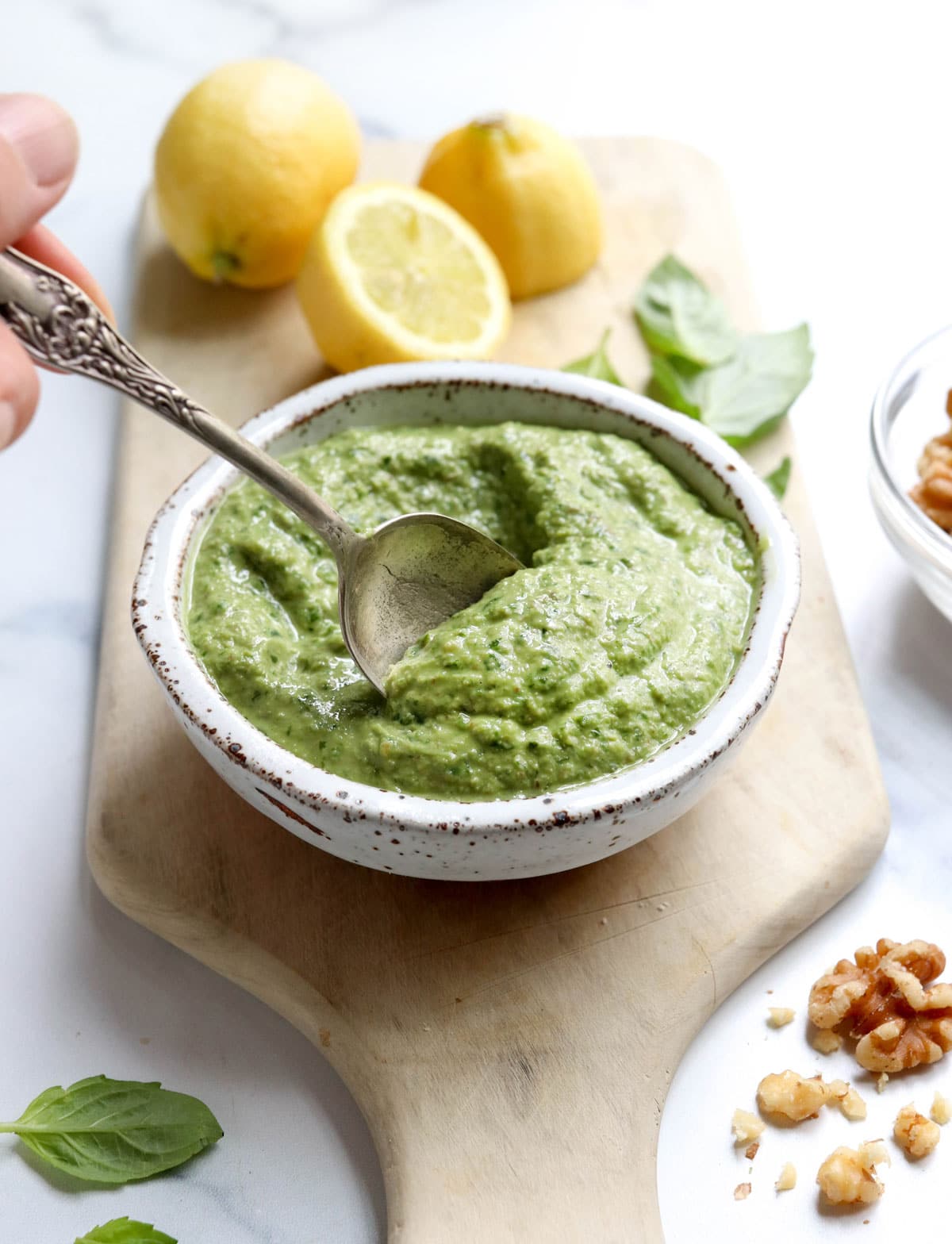 vegan pesto with spoon and lemons