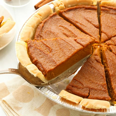 vegan pumpkin pie sliced and lifted up from the pan.