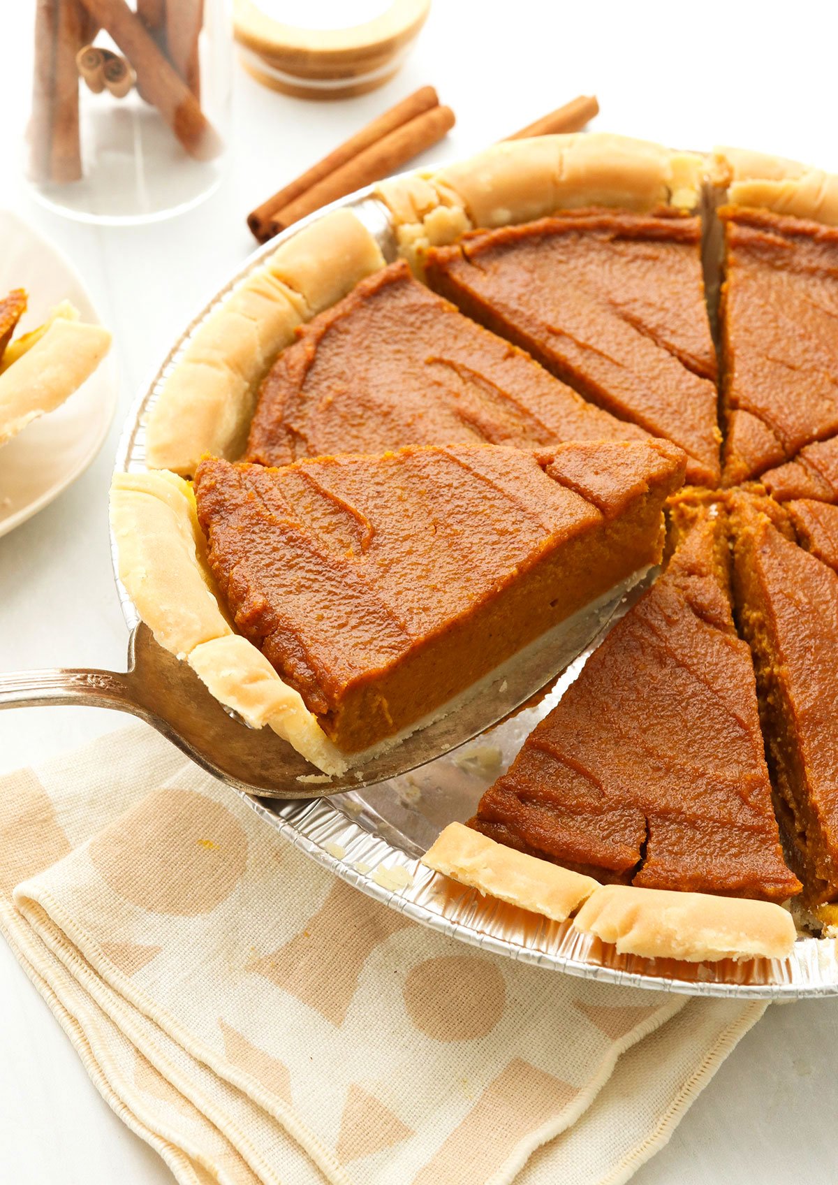 vegan pumpkin pie sliced and lifted up from the pan.