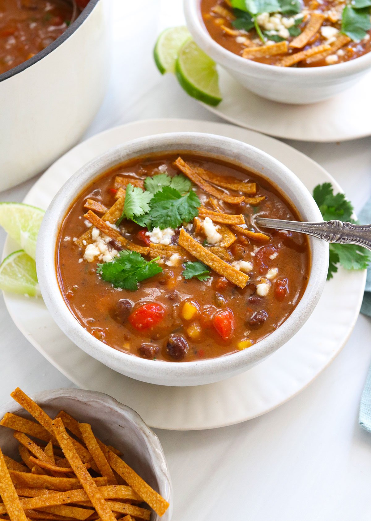 vegan tortilla soup topped with crispy tortilla strips.