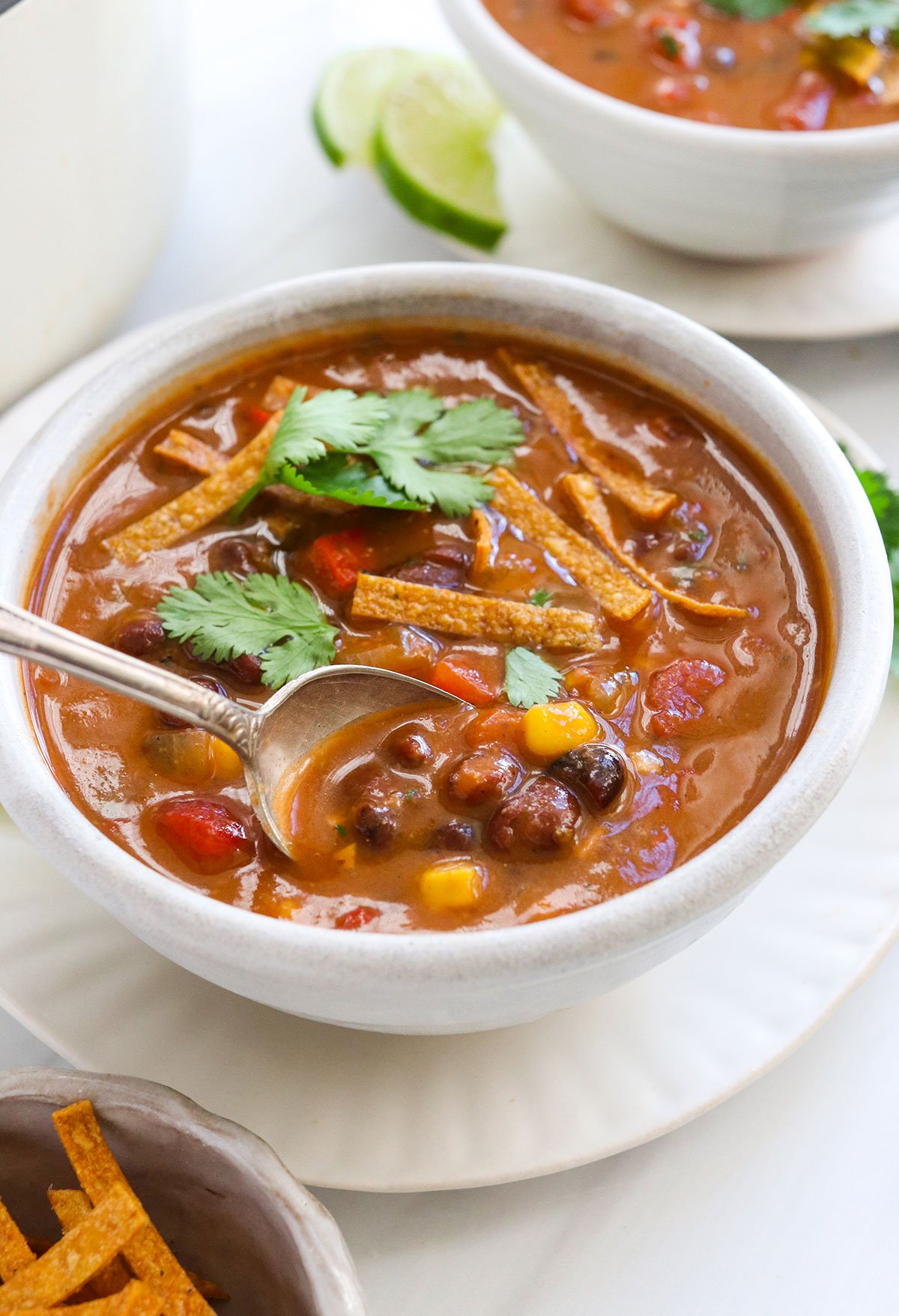 vegan tortilla soup lifted from the bowl on a spoon.